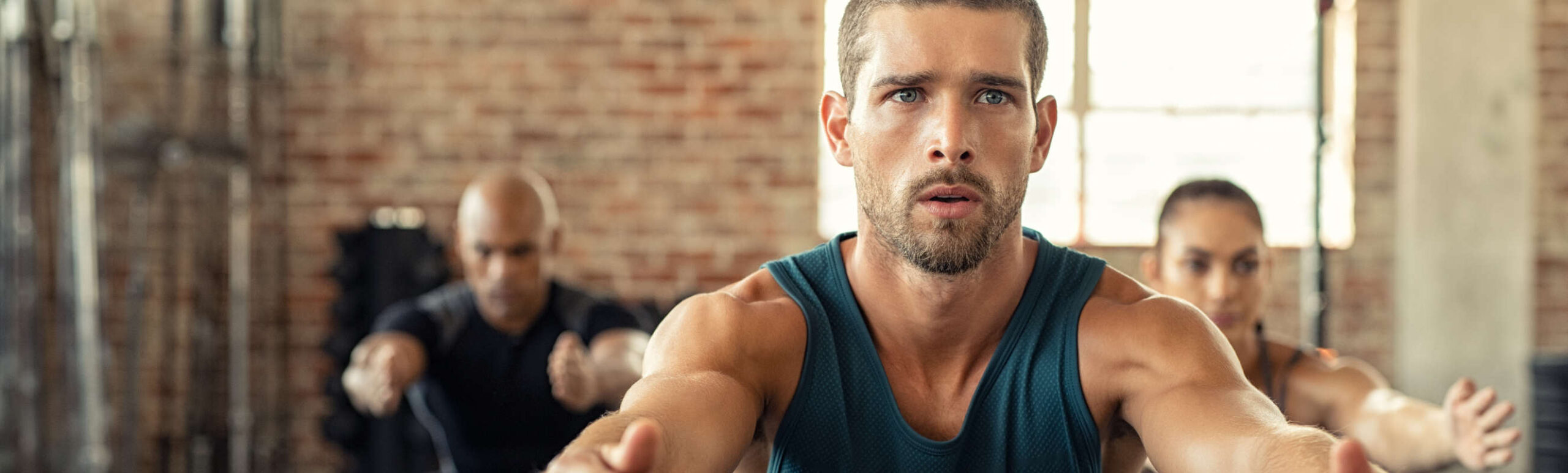 Fitness man squatting with class at gym